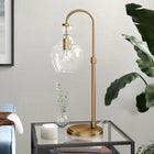 Hudson&Canal - Lampe de table arquée Verona de 68 cm de haut avec abat-jour en verre - Laiton brossé/transparent-Une finition en laiton brossé fabriquée à la main est appliquée sur la base géométrique en métal