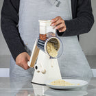 NutriSlicer Stainless Steel Rotary Cheese Grater and Vegetable Slicer - Cream-Includes 3 interchangeable stainless steel blade drums, a slicer, a fine shredder, and a coarse shredder for precise cuts every time